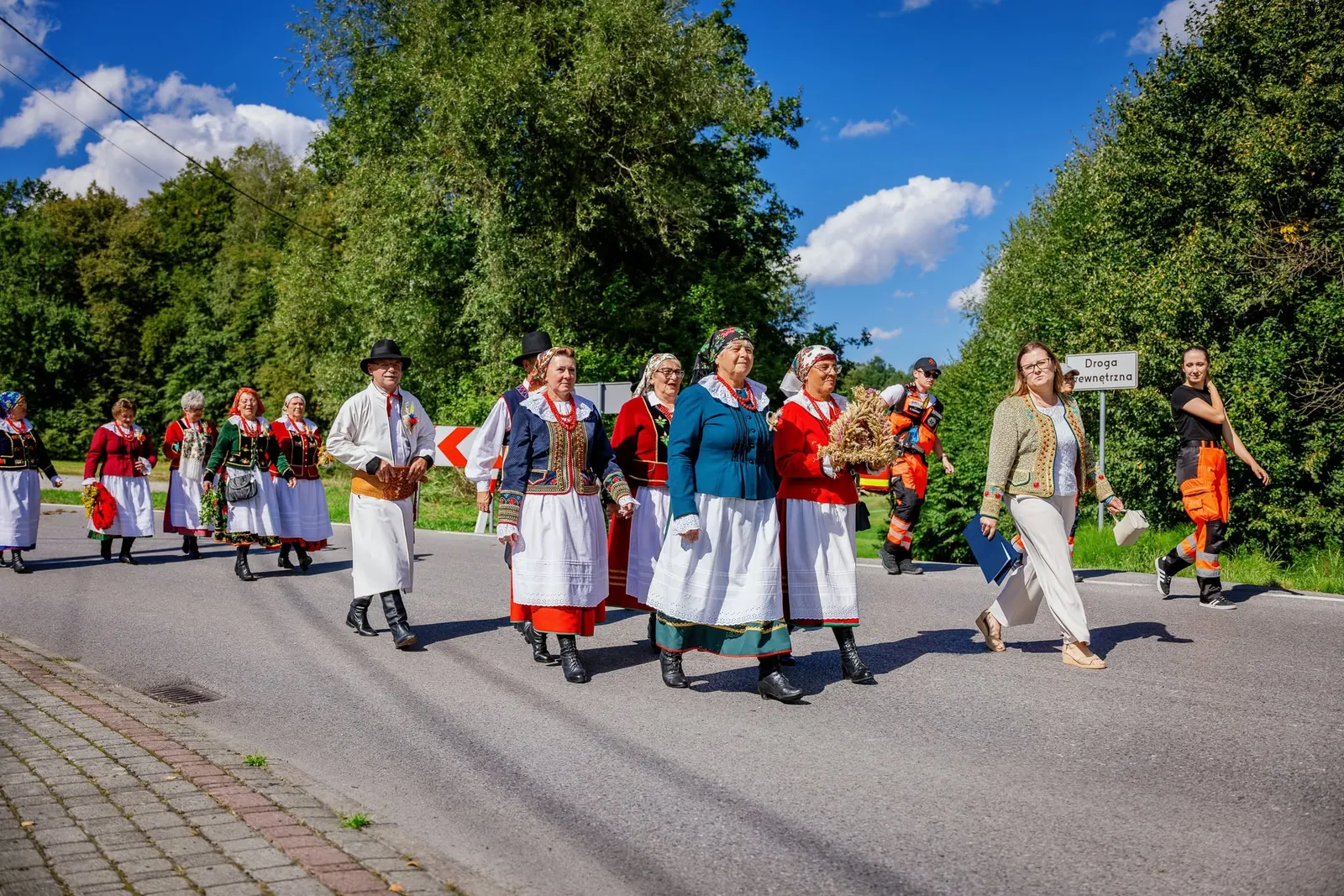 Korowód dożynkowy w strojach ludowych na drodze w Sieprawiu